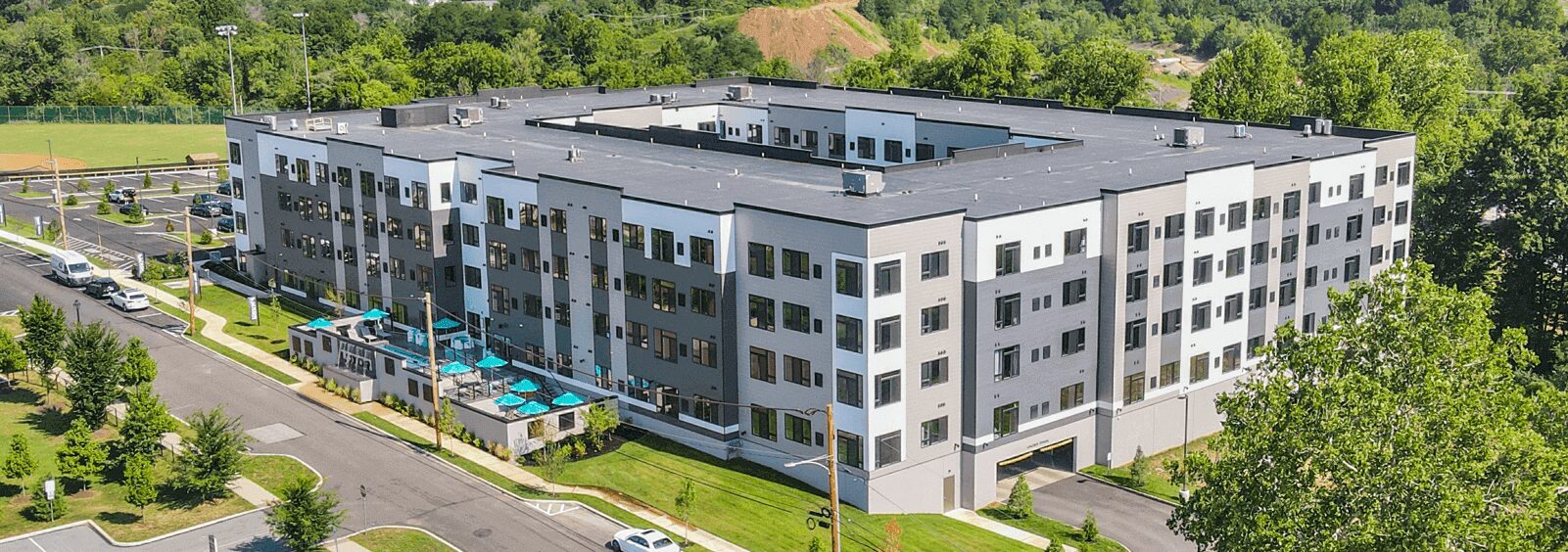 An aerial view of a building with trees in the background.