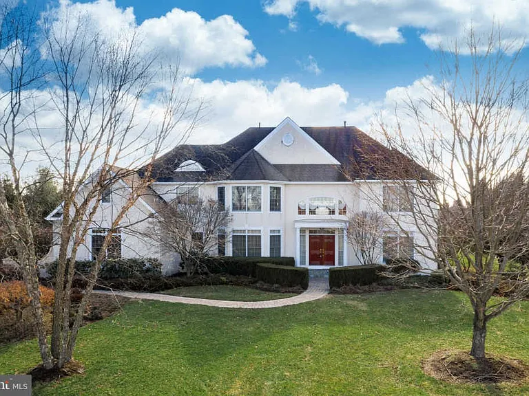 Westrum Corporate Large two-story white house in Hopewell Township with red double doors, front lawn, bare trees, and a curved walkway under a blue sky.