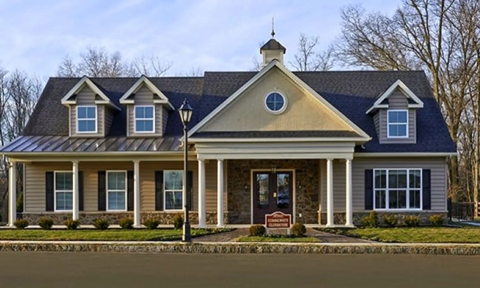 Westrum Corporate A two-story suburban house with a front porch, gabled roof, and a small West Goshen Township sign in the front yard.
