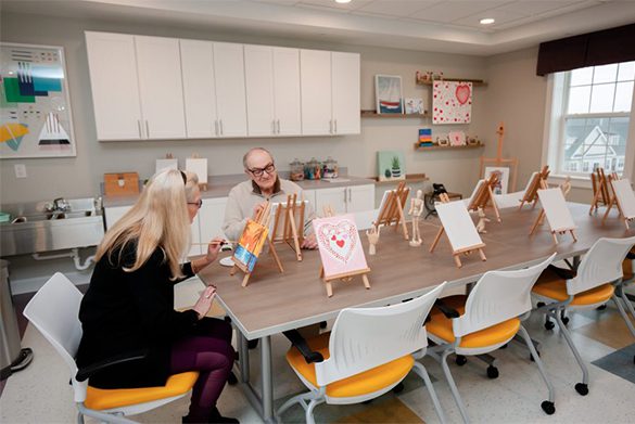 Westrum Corporate Two older adults paint at easels in a bright art room at Pointe@31 Brewerytown, reflecting community excellence and creativity.