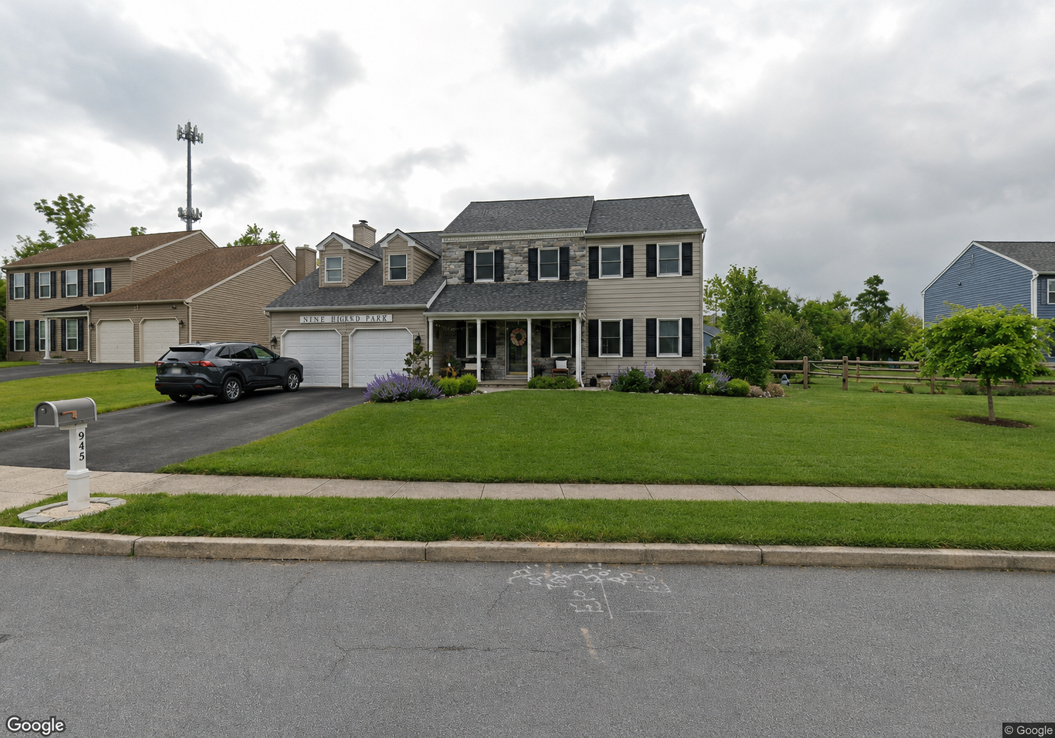 Westrum Corporate Two-story Highland Park II suburban house with front lawn, driveway, and a black SUV parked outside on a cloudy day.
