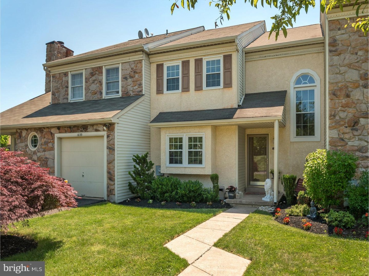 Westrum Corporate Charming two-story home in The Meadows with stone and stucco exterior, attached garage, front yard, and a welcoming stone path to the entrance.