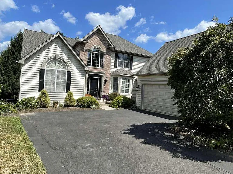 Westrum Corporate Two-story home in Orchards at Jericho with arched window, attached garage, manicured shrubs—explore Jericho real estate today!.
