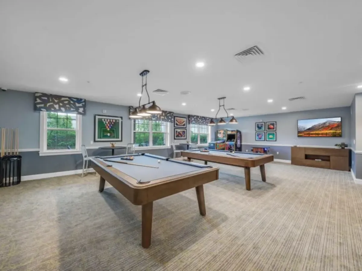 Westrum Corporate Spacious game room at Pinnacle at Plymouth Meeting with pool tables, wall art, TV, large windows, and gaming machines.