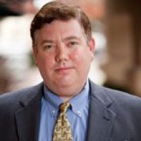 Westrum Corporate Kevin Gillen, Ph.D., stands outdoors in a suit and patterned tie, looking at the camera with a neutral expression.