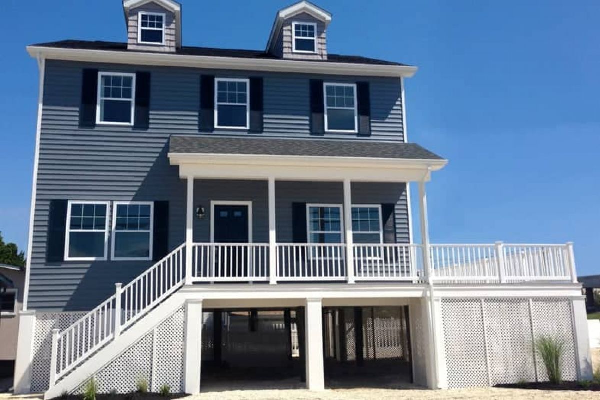Westrum Corporate Two-story blue house with white trim and large deck, nestled in Seaside Heights Borough under the clear Jersey Shore sky.