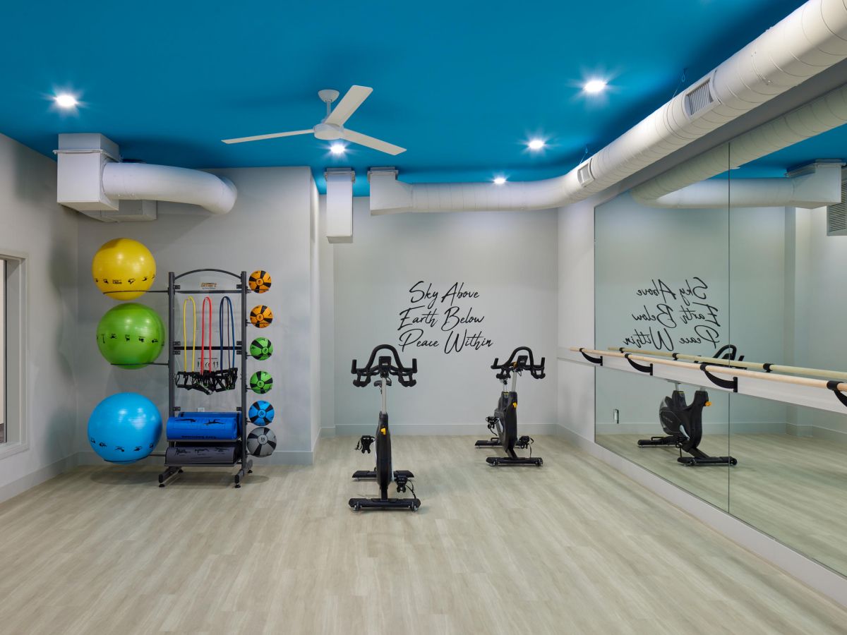 Westrum Corporate The Luxor Montgomeryville apartments feature a bright fitness room with bikes, wall mirrors, and colorful exercise balls.