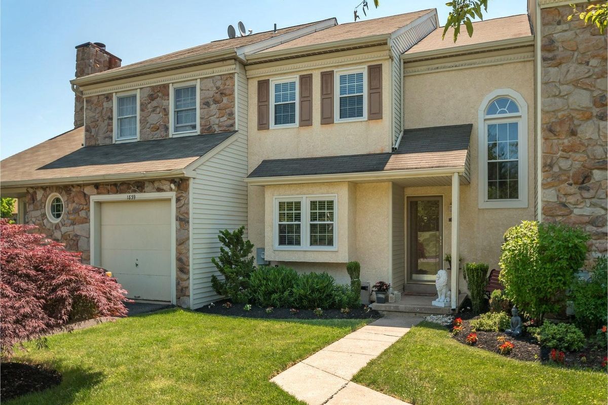 Westrum Corporate Charming two-story home in The Meadows with stone and stucco exterior, attached garage, front yard, and a welcoming stone path to the entrance.