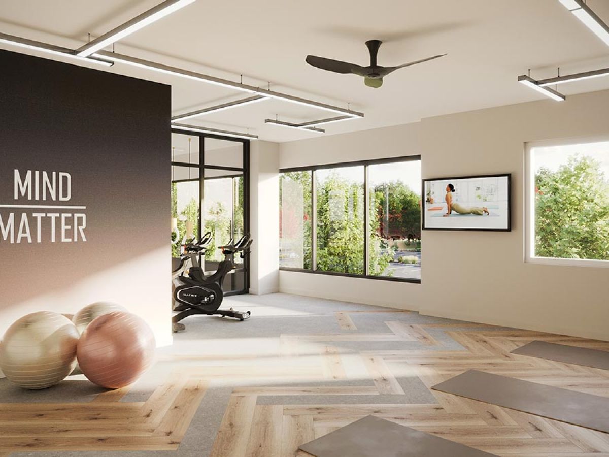 Westrum Corporate Bright fitness room at Luxor Fort Washington with yoga mats, exercise balls, bikes, TV, large windows, and “Mind Matter” on the wall.