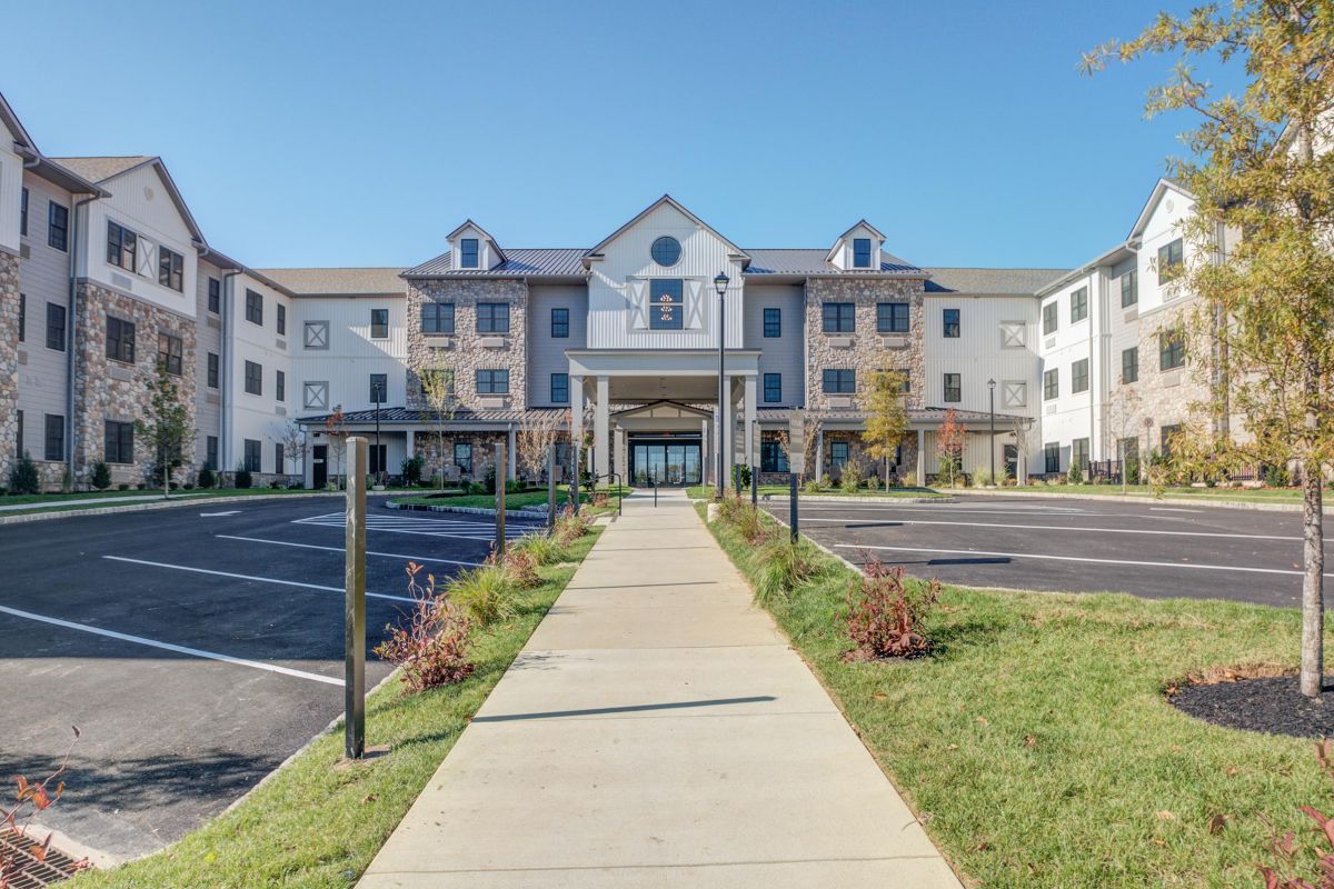 Westrum Corporate A modern three-story Mercer Hill building with stone accents, perfect for senior living in Doylestown, on a clear day.