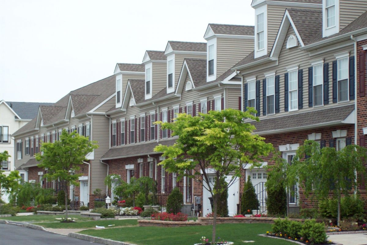 Westrum Corporate Row of modern townhouses in Reserve at Packer Park, with brick fronts and manicured lawns, lines a quiet Philadelphia street.