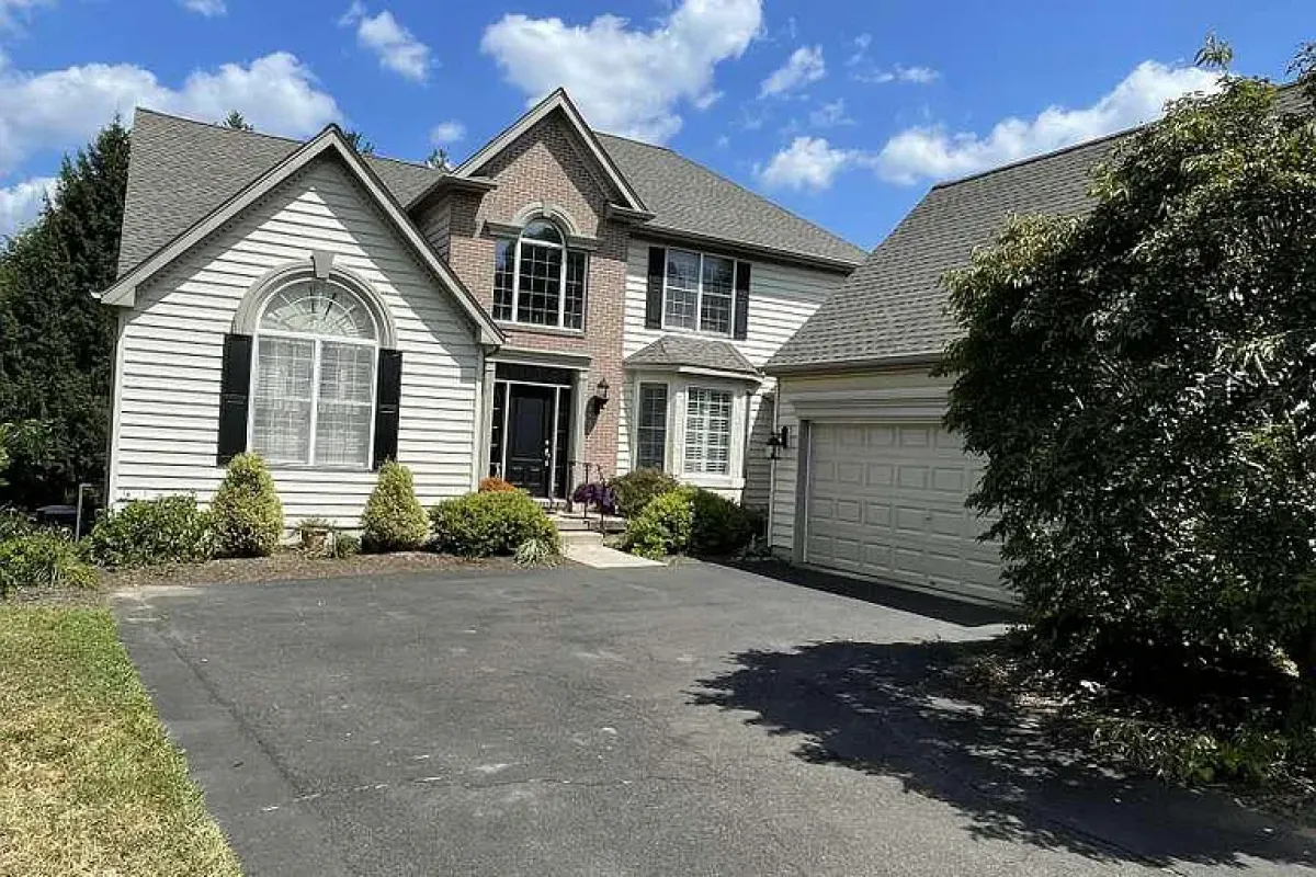 Westrum Corporate Two-story home in Orchards at Jericho with arched window, attached garage, manicured shrubs—explore Jericho real estate today!.