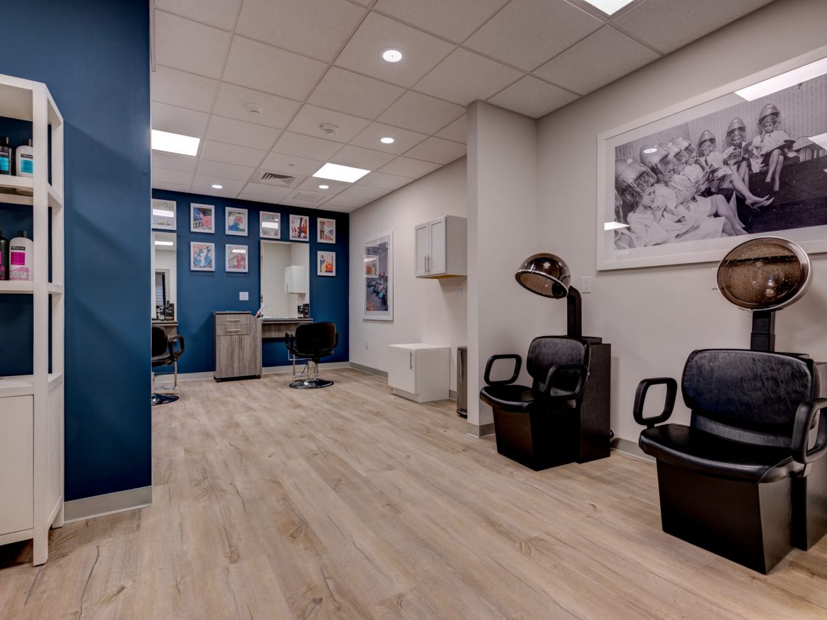 Westrum Corporate Modern salon in Crescent Fields, Huntingdon Valley, with two black hair dryers, chic chairs, artful walls, and colorful hair products.