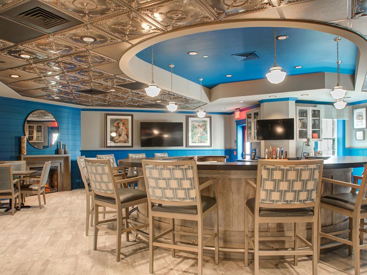 Westrum Corporate Modern bar at Mercer Hill with patterned chairs, metallic tiles, wall art, and pendant lighting in a bright, stylish Doylestown space.