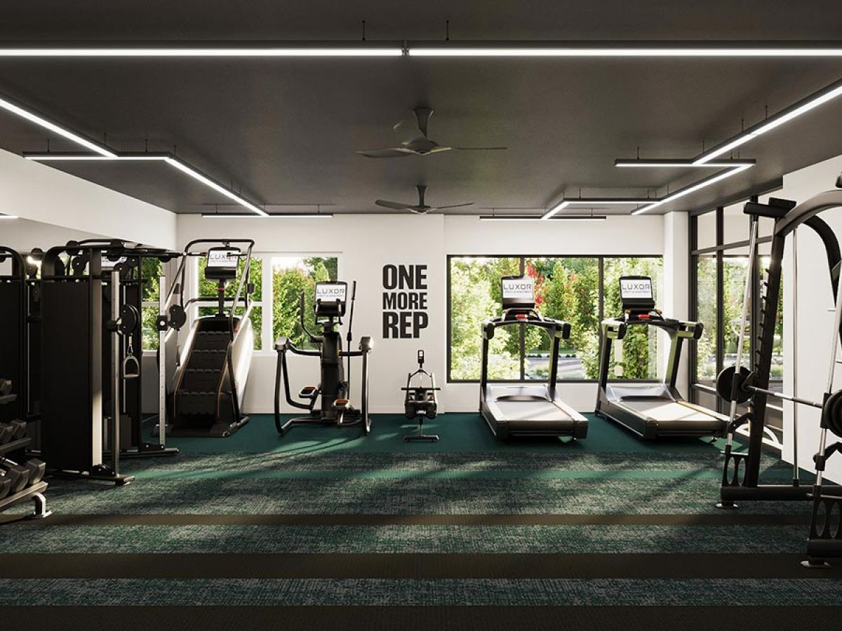 Westrum Corporate Modern gym at Luxor, Fort Washington with treadmills, weights, large windows, and a motivating “One More Rep” sign.