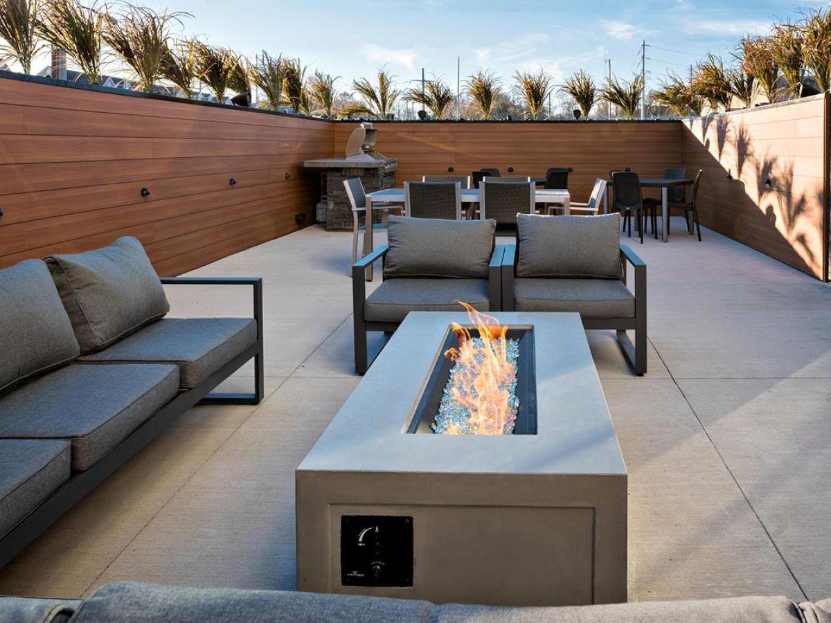 Westrum Corporate Modern patio at Pointe at 31 with gray sofas, fire pit, and lush plants—perfect for Brewerytown apartments in Philadelphia.