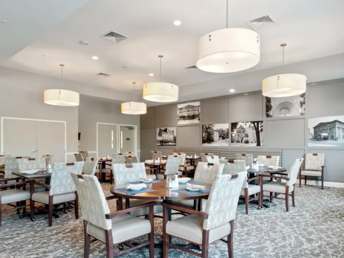 Westrum Corporate Spacious, well-lit dining room at Arbour Square in West Chester with modern fixtures, cushioned chairs, and black-and-white photos.