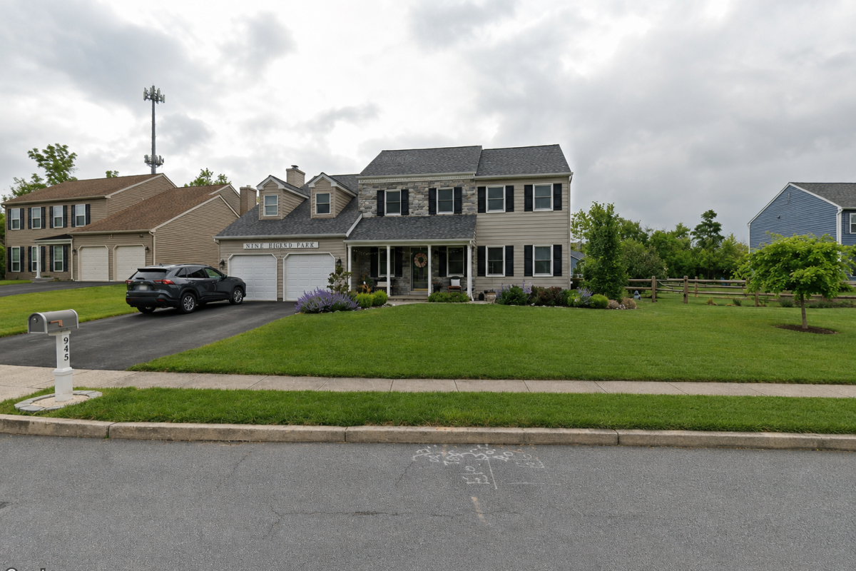 Westrum Corporate Two-story Highland Park II suburban house with front lawn, driveway, and a black SUV parked outside on a cloudy day.