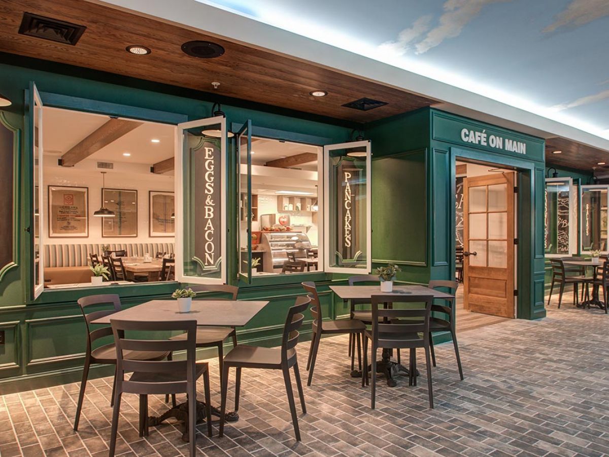 Westrum Corporate Charming outdoor seating at a green café near Mercer Hill, with open windows and menu signs, perfect for Doylestown visitors.
