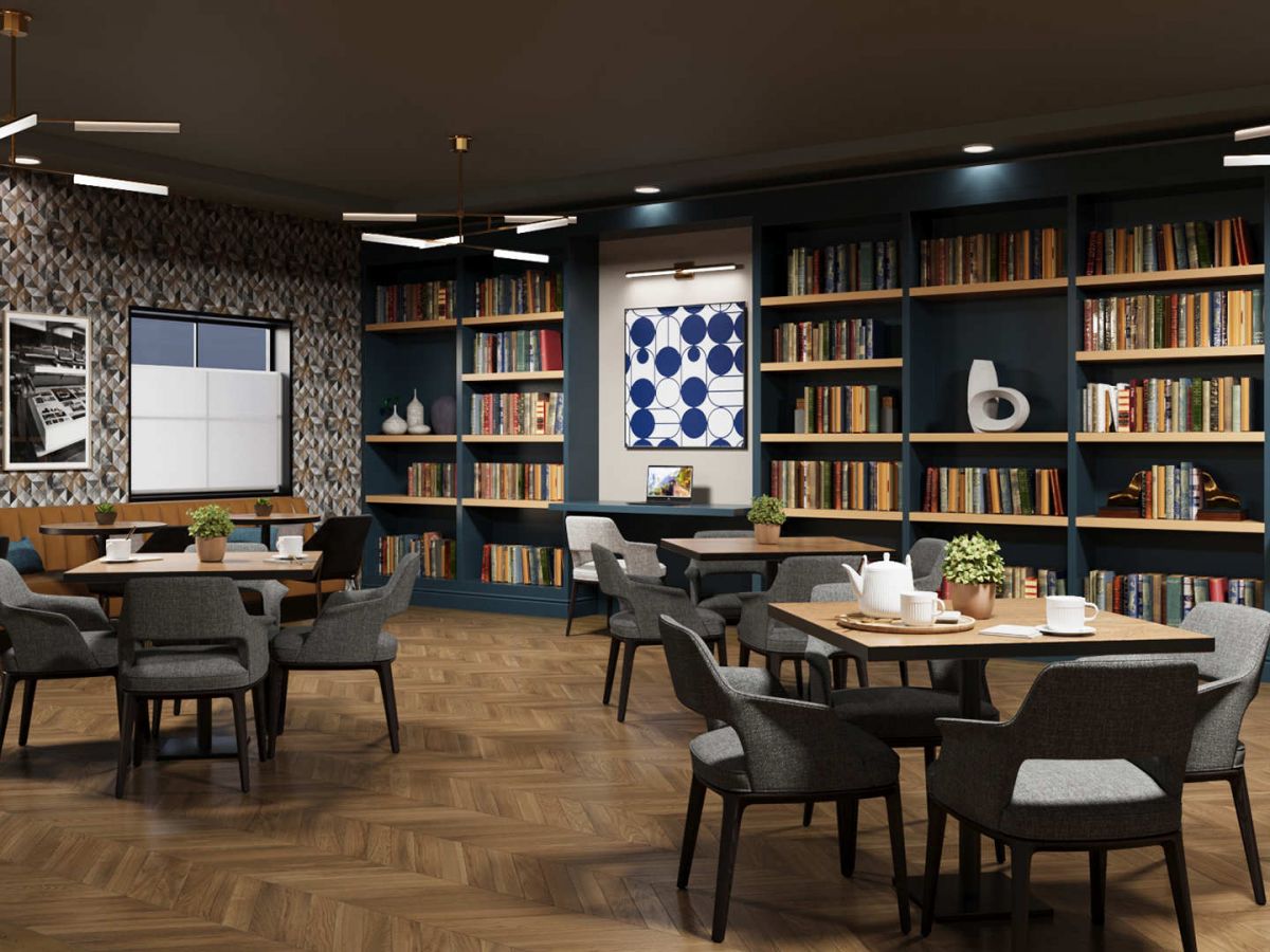 Westrum Corporate Modern library lounge at Aviv at Radnor features bookshelves, round tables, gray chairs, wooden floor, and geometric wall art.