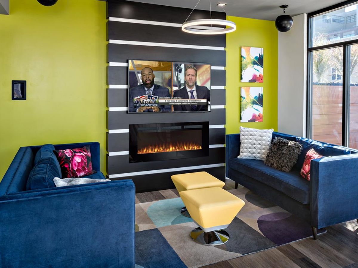 Westrum Corporate Modern living room at The Pointe at 31 Brewerytown with blue sofas, yellow walls, and vibrant decor—experience luxury apartments in style.