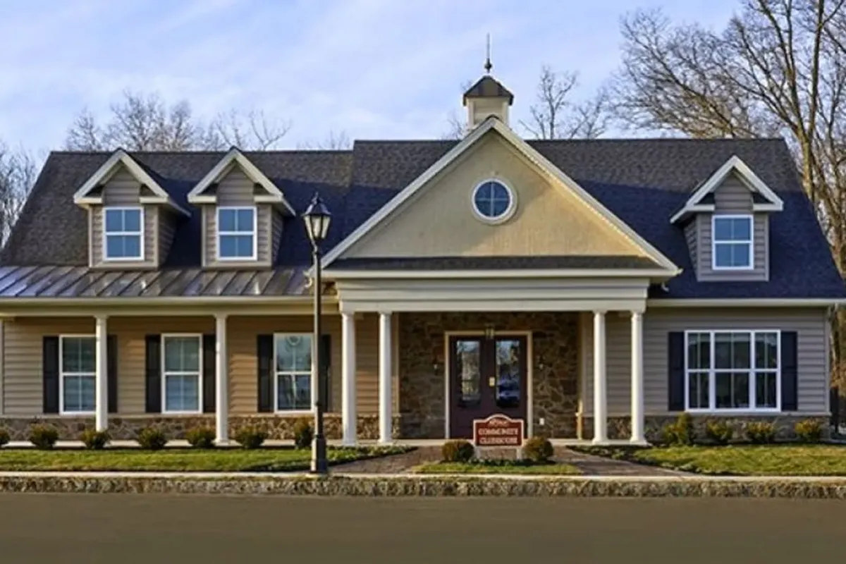 Westrum Corporate A two-story suburban house with a front porch, gabled roof, and a small West Goshen Township sign in the front yard.