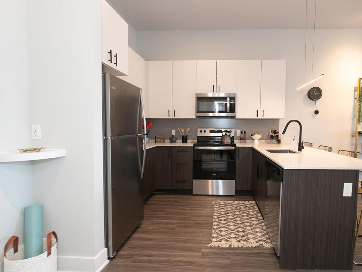 Westrum Corporate Modern kitchen in Bala Cynwyd luxury apartments features stainless steel appliances, sleek cabinets, island sink, and bar stools.